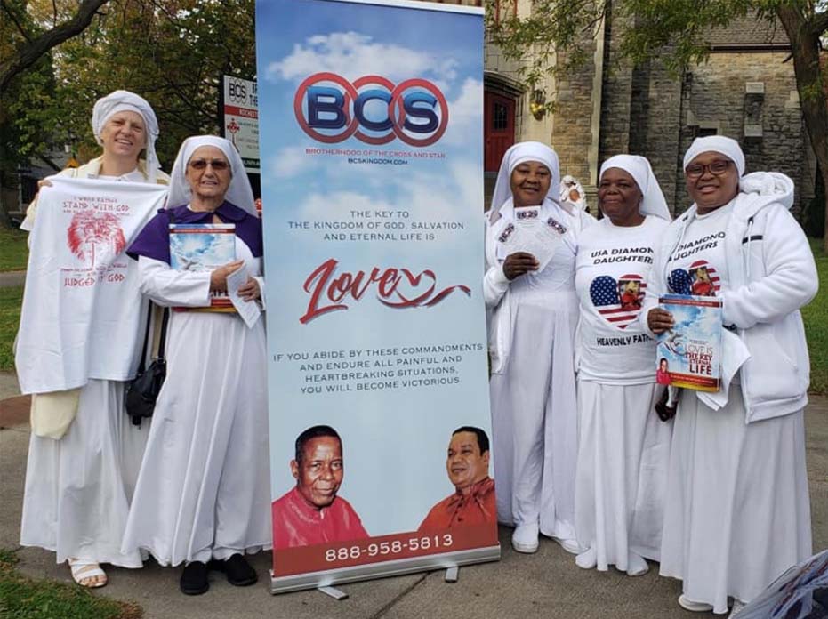 Group of women in white robes with banner