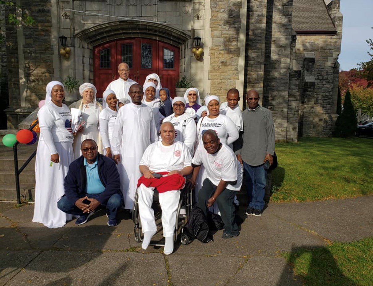 Group of people in white garments outside church